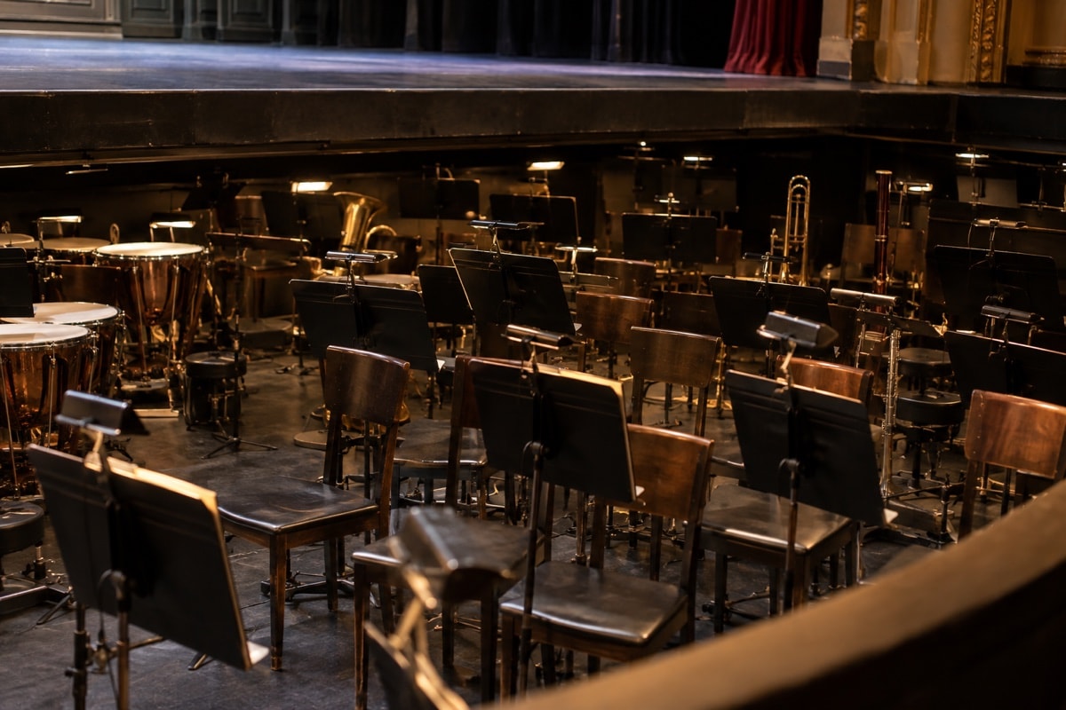 Chairs and black music stands in an empty orchestra pit